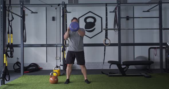 Caucasian Man in a Gym with a Kettlebell