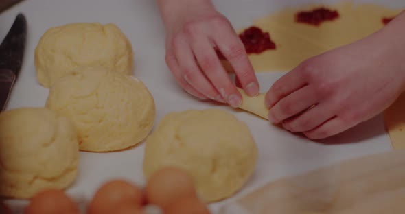 Woman Making Tasty Croissants on Table in Kitchen