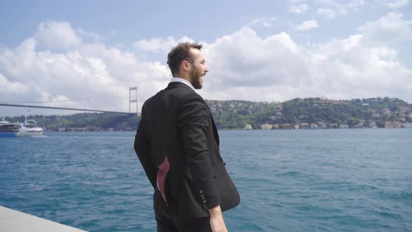 Businessman celebrating his success by the sea.