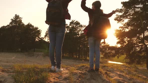 Girls Travel with Backpacks on a Country Road