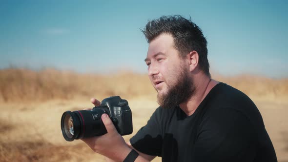 Slow Motion Concentrated Handsome Man Looking in Pro Camera Window and on Screen