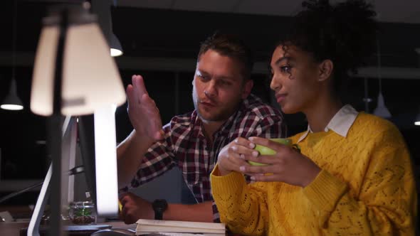 Young office executives discussing over computer in a modern office