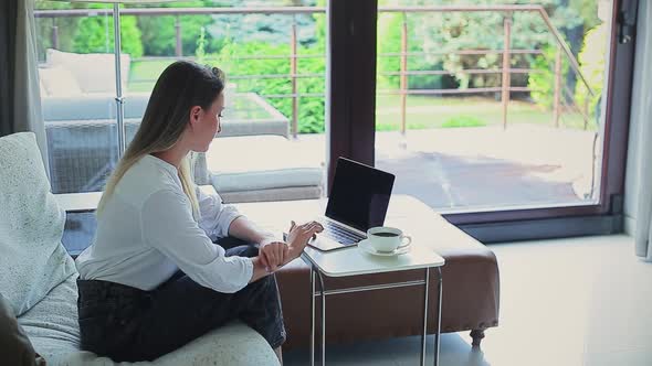 Beautiful Girl on the Couch Working on a Laptop