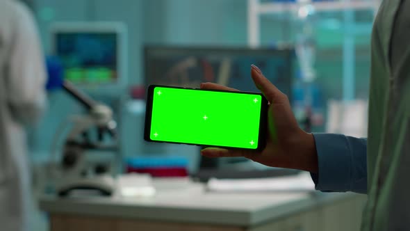 Close Up of Scientist Holding Horizontal Phone with Green Mockup