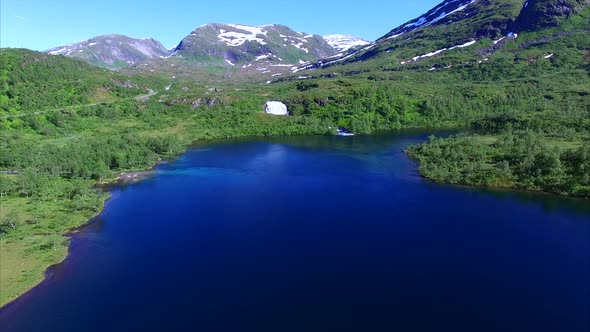 Scenic lake with waterfall in Norway, aerial view