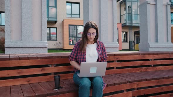 The Girl Works Remotely in the Park