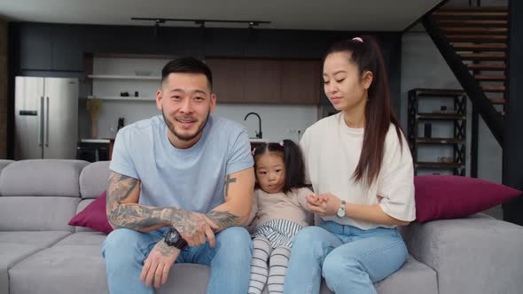 Lovely Asian Family with Toddler Girl Relaxing at Home