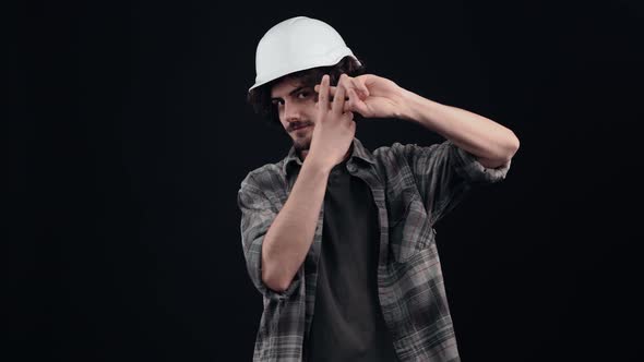 An Engineer Who Makes a Hashtag Gesture on the Camera with a Toothy Smile Wears a Special Helmet on