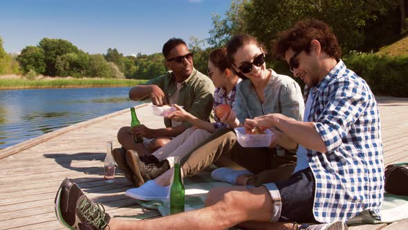 Friends Having Picnic on Lake Pier