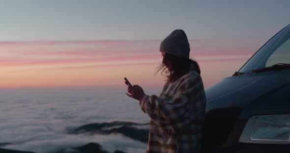 Beautiful Young Woman with a Phone at Sunset