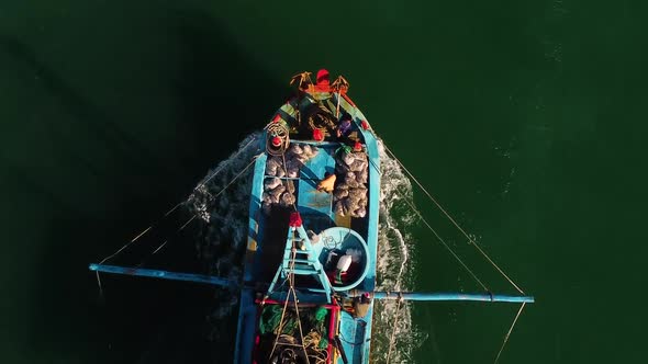 A vertical shot of a fishing boat sailing through the sea waters in Vietnam.