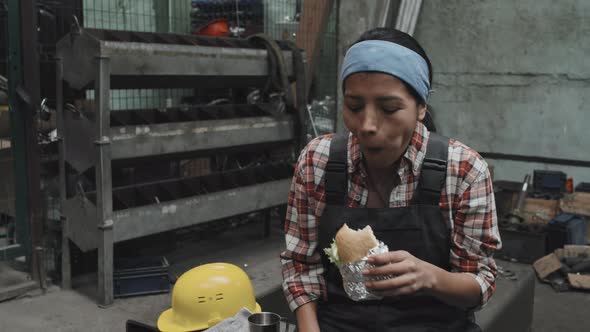 Woman Eating at Factory