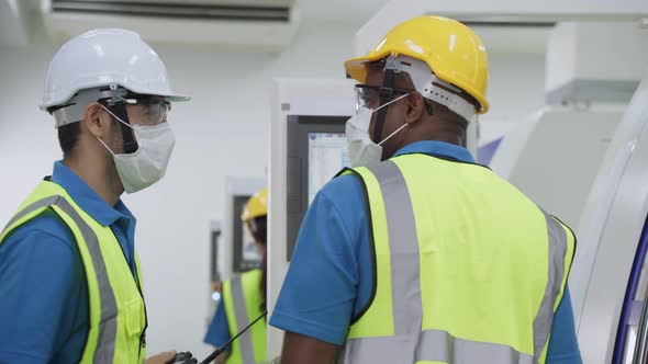 Group of diversity worker people wearing protective face mask in production factory due to covid 19.