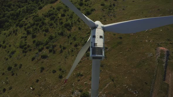 Zoom Out for a Wind Turbine Propeller and Opening Aerial View on a Wind Farm in the Mountains with