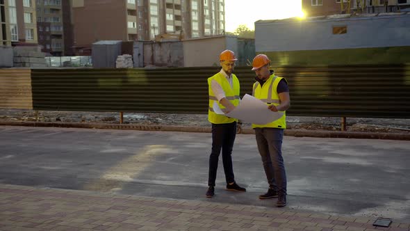 Two Men Discuss Their House Project on a Road