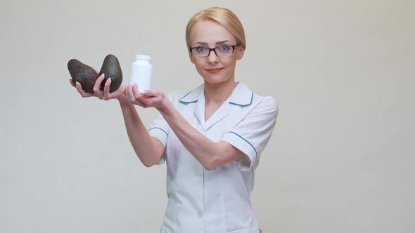 Nutritionist Doctor Holding Organic Avocado Fruit and Jar of Medicine or Vitamin or Omega 3 Capsules