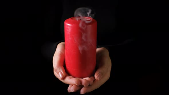 Red Burning Candle in a Woman Hand.