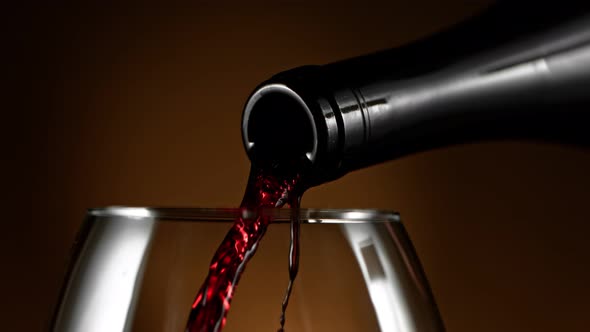 Super Slow Motion Detail Shot of Pouring Red Wine From Bottle on Luxury Background at 1000Fps alt