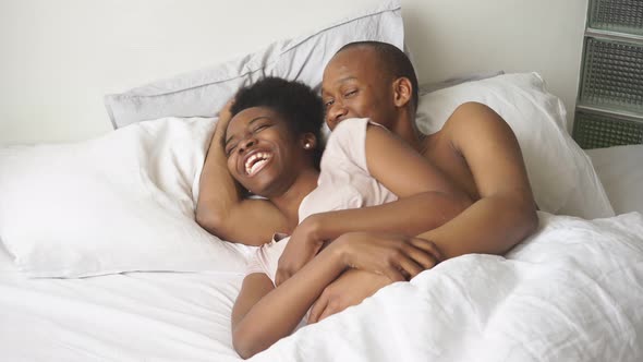 Happy Afroamerican Married Couple Lie on Bed