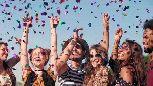 Group of friends dancing in confetti