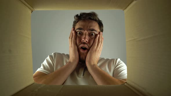 Bottom View Amazed Man Looks Into the Empty Box From the Inside