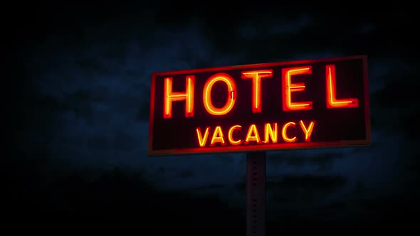 Neon Hotel Sign With Clouds Passing