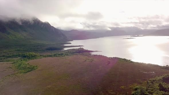 Aerial flight over foggy mountains and reflective lake Tasmania in Australia, long distance shot mov