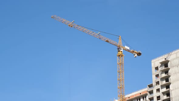 Building Under Construction. Cranes on Blue Sky Background