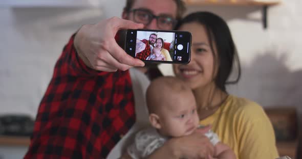 Young Couple Taking Selfie with Baby