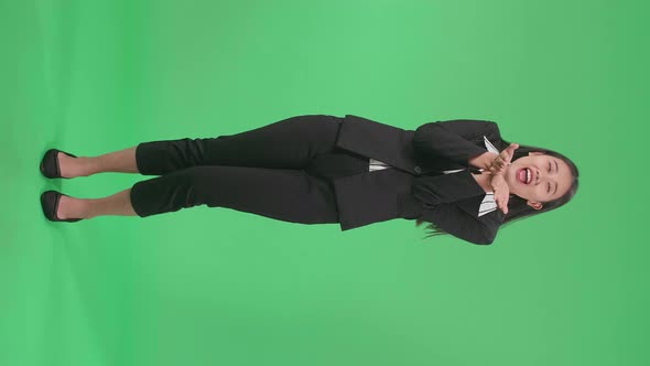 Full Body Of Asian Business Woman Blowing Kisses And Smiling To Camera In The Green Screen Studio