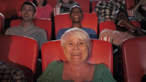 Joyful Aged Female Watching Comedy in Cinema