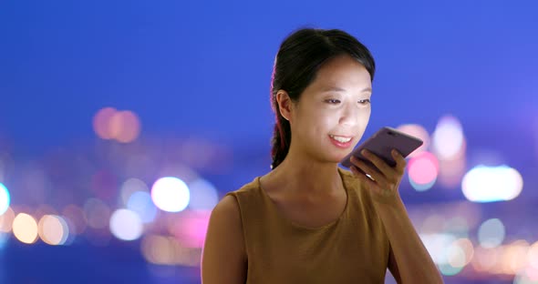 Woman use of mobile phone in city of Hong Kong at night