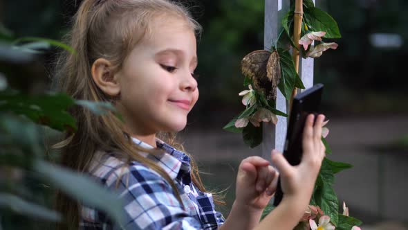 A Girl Takes a Selfie with a Butterfly