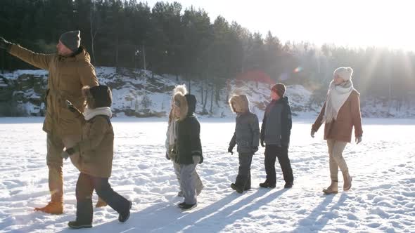 Young Family Walking Together in Snow