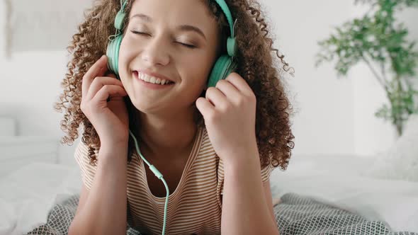 Young Woman Listening to Music in Her Bed