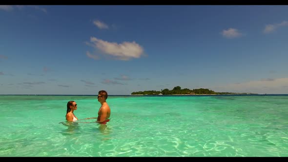 Two lovers tanning on exotic sea view beach holiday by blue sea with white sand background of the Ma