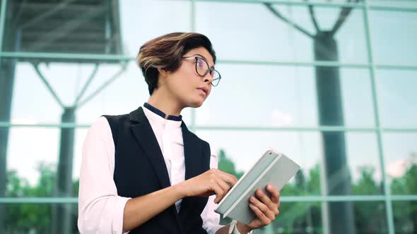 Young Beautiful Businesswoman Looking at Tablet Business Centre Background