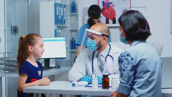 Cheerful Pediatrician Smiling at Little Girl