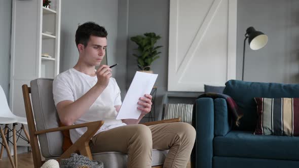 Reading Man Going Through Contract PaperWork