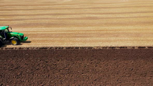 A Tractor Plows a Harvested Corn Field for Future Planting. View From Above