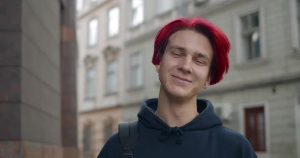 Portrait of Young Hipster Man with Red Dyed Hair Looking To Camera. Close Up View of Millennial Guy