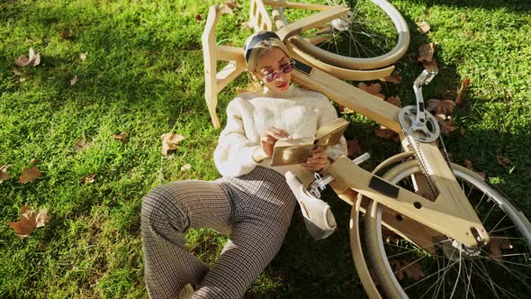 Woman with Wooden Eco Bike Reading a Book