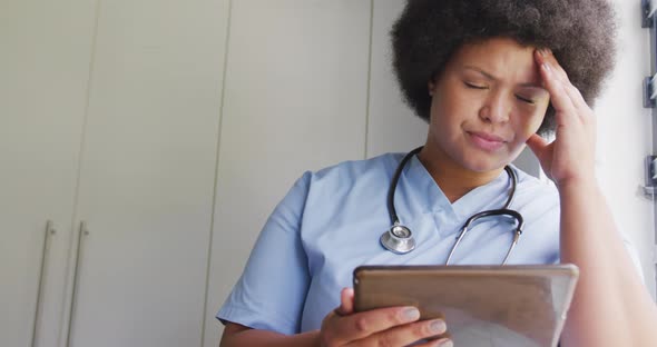 Video of tired plus size african american female doctor using tablet