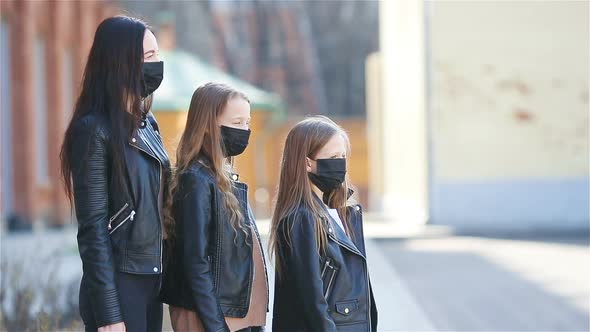 Family Wearing a Mask on a Background of a Modern Building,