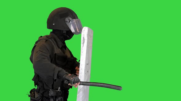 Riot Policeman Hitting Shield with the Baton While Walking on a Green Screen Chroma Key