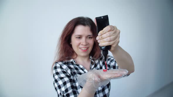 Beauty and Hair Care Concept.. Happy Young Woman with a Tube of Hair Dye