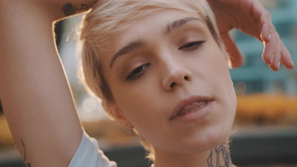 Portrait of Beautiful Young Short Haired Blond Woman in the Park During the Sunset