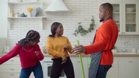 Portrait of Excited Black Family Having Fun During Cleanup