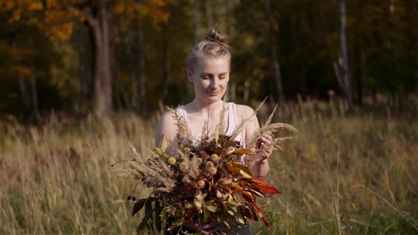 Woman Looking at Bouquet of Wild Flowers in Summer