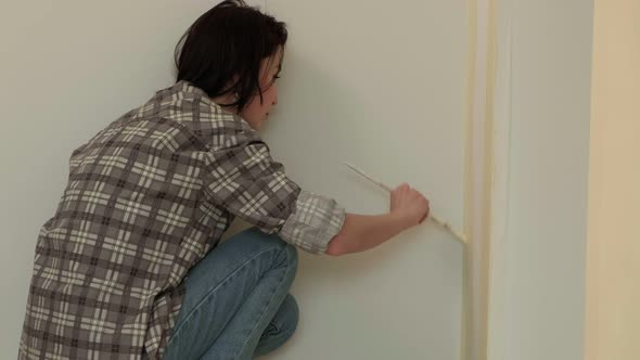 Female House Painters Paint the Walls in the Room.